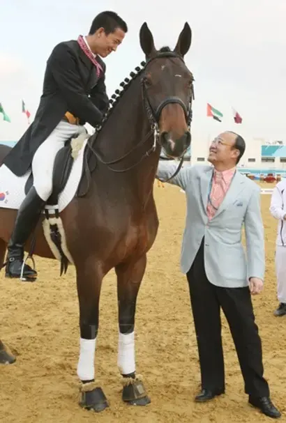 지난 2006년 12월 4일 도하아시안게임 마장마술 단체전에서 한국 대표팀이 금메달을 딴후 김승연 한화그룹 회장이 국가대표로 출전한 3남 김동선 씨를 축하해주고 있다. 사진=연합뉴스