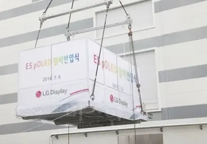 지난해 7월 LG디스플레이 E5공장에서 6세대 POLED(Plastic OLED) 라인의 성공적인 셋업을 기원하는 POLED 장비 반입식이 열렸다. 핵심장비가 공장 안으로 반입되고 있는 모습.  사진=LG디스플레이 블로그 화면 캡처