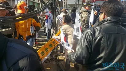 한 집회 참가자가 펜스를 집어던지며 무대로 달려가고 있다. 사진=봉성창 기자