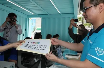 강병준 쿠팡사태대책위원회 위원장이 5월 30일 오전 서울 광화문 한글공원 내 열린광장에 위치한 국민인수위원회의 ‘광화문1번가’에 쿠팡의 비정규직 대량 해직 사태 및 부당 노동행위에 대한 76인의 탄원서를 접수하고 있다. 사진=연합뉴스