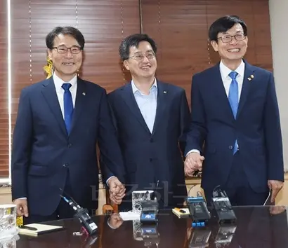 김동연 부총리 겸 기획재정부 장관(가운데)이 6월 21일 정부서울청사에서 열린 현안간담회에 참석해 장하성 청와대 정책실장(왼쪽), 김상조 공정거래위원장과 손을 맞잡고 기념사진을 찍고 있다. 사진=기획재정부