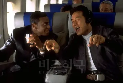 ‘러시아워’​ 스틸컷. 성룡이 함께 출연한 크리스 터커(왼쪽)와 비행기 안에서 노래를 들으며 이야기하고 있다.