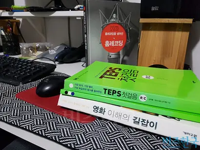 B 씨의 반지하 방 구석에 있는 마이크와 키보드가 보였다. 책상 위로는 ‘TEPS’와 ‘홈레코딩’ 도서가 가지런히 놓여 있었다. 사진=김종용 인턴기자