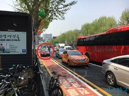 전용차로에 정차된 자동차로 인해 자전거 이용자가 불가피하게 자동차 차로로 우회하고 있다. 사진=김상훈 기자