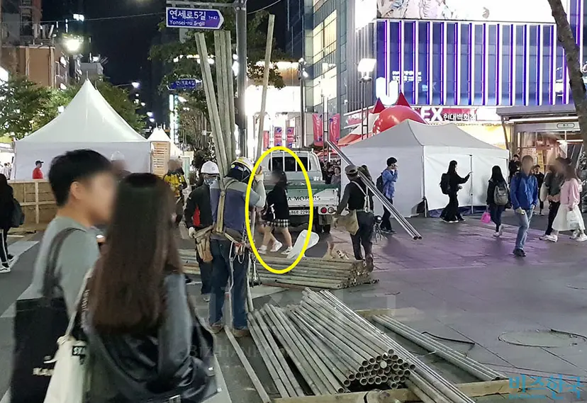 인부들이 철제빔을 옮기는 아래로 행인들이 무심하게 지나고 있다. 사진=우종국 기자