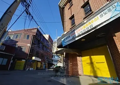 가게들이 문을 닫은 옐로하우스 골목의 낮 모습. 재개발 관련 현수막이 건물에 걸려 있다. 사진=이성진 기자