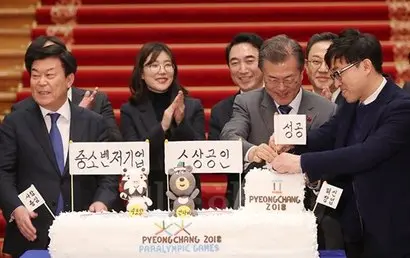 문재인 대통령이 지난해 1월 청와대에서 열린 중소·벤처기업 및 소상공인과의 대화에 앞서 동네 빵집을 협동조합화해 경쟁력을 강화한 인천 패밀리베이커리에서 제작한 ‘2018년 중소벤처기업 및 소상공인, 평창 동계올림픽 성공기원’ 케이크를 바라보고 있다. 사진=청와대 제공