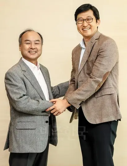 손정의 소프트뱅크 회장(왼쪽)과 김범석 쿠팡 대표가 일본 도쿄에 있는 소프트뱅크그룹 본사에서 악수하며 기념 촬영을 하고 있다. 사진=쿠팡 제공