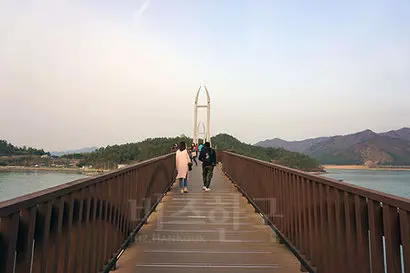 강진만 한가운데 자리잡은 가우도와 육지를 연결하는 출렁다리. 중앙에 소뿔처럼 날카로운 교각이 솟아올랐다. 사진=구완회 제공