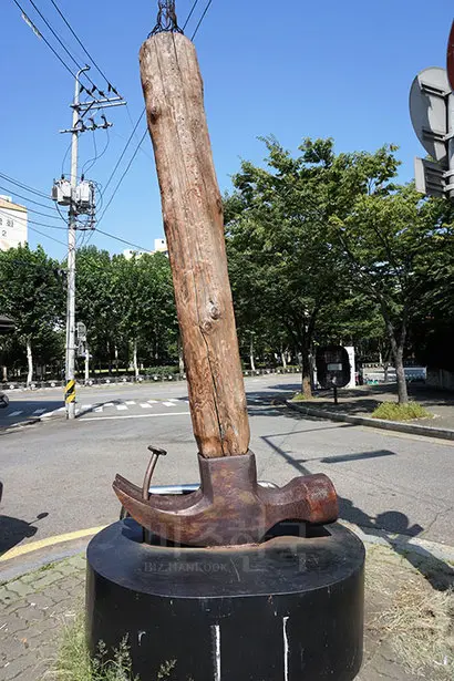 ‘문래창작촌 인포메이션’ 부스 옆에 세워진 거대한 망치와 못 조형물. 사진=구완회 제공