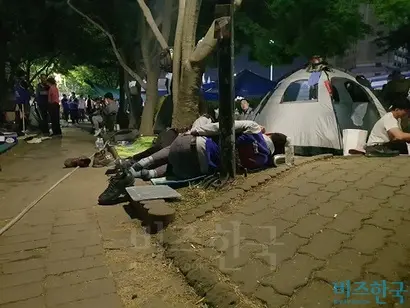 30일 저녁 9시 20분을 넘어섰을 무렵, 집회는 계속되고 있었지만 대열을 빠져나온 노조원들은 자리를 깔고 등을 대고 누웠다. 사진=박현광 기자