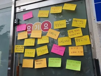 기자회견에 참석한 라이더들은 포스트잇에 요구사항을 적어 요기요플러스 성북허브 입구에 붙였다. 사진=김보현 기자