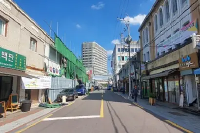 사진 왼쪽 초록색 가림막이 쳐진 곳에서 주상복합건물 공사가 진행 중이다. 오른쪽 가게들은 영업 중이다. 사진=김보현 기자