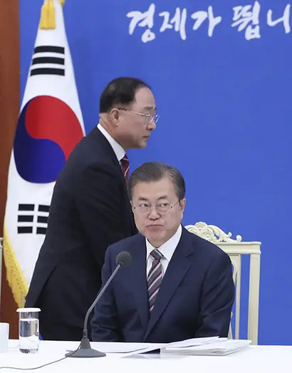 문재인 대통령이 19일 청와대에서 열린 확대경제장관회의에 참석해 있다. 왼쪽은 2020 경제 관련 보고를 위해 이동하는 홍남기 경제부총리 겸 기획재정부 장관. 사진=연합뉴스