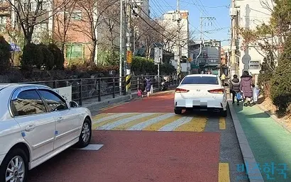 서울시 한 초등학교 어린이 보호구역. 뒤편에서는 차량이 진입 중인데도 두 어린이가 차도로 걷고 있다. 사진=박찬웅 기자
