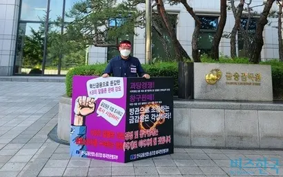 KB국민은행 노조는 리브엠 대면 서비스 강화를 통한 휴대폰 판매 압박은 은산분리 원칙과 금융위 승인 부가조건 반하는 것이라는 입장이다. 사측은 아직 결정된 것은 없다면서 노조측과 조율 중인 상황이라고 해명했다. 금융감독원 앞에서 시위중인 류제강 KB국민은행 노조위원장. 사진=KB국민은행 노조