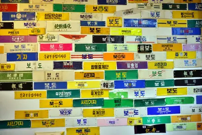 옛 교실 벽 한쪽을 채우고 있는 기자 완장. ‘보도’, ‘촬영’, ‘PRESS’라는 문구가 적힌 완장들은 고 관장이 직접 사용하거나 선후배 기자들에게 기증받은 것이다. 사진=구완회 제공