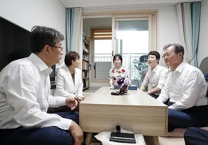 문재인 대통령이 2018년 7월 5일 서울 구로구의 한 행복주택 아파트 광장에서 열린 신혼부부 및 청년 주거대책 발표 행사가 끝난 뒤 참석 입주민들과 자리를 함께 한 모습. 사진=청와대 제공