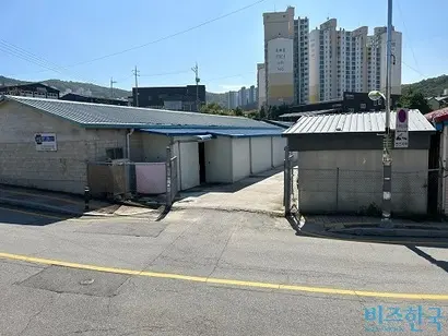 부지 앞 아파트 앞에는 반대 현수막(위)이 걸려 있다. 인근 창고 시설. 사진=강은경 기자