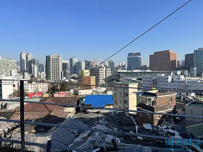 서계·청파언덕 꼭대기 전망대에서 바라본 전경. 판자로 가려진 집들 너머로 보이는 고층 빌딩들. 사진=양보연 인턴기자