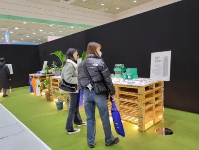 방문객들이 굿즈 쇼케이스에 전시된 롯데칠성음료의 콜라보 굿즈를 감상하고 있다. 사진=심지영 기자