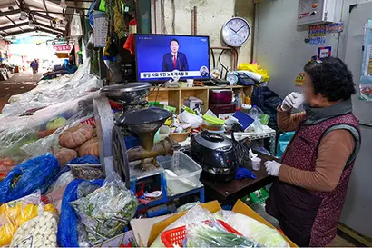 2024년 첫날인 1일 오전 서울 시내 한 전통시장에서 한 상인이 윤석열 대통령의 2024년 신년사 중계방송을 지켜보고 있다. 사진=연합뉴스