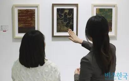지난해 부산국제아트페어에서 설민기 작가(오른쪽)가 관람객에게 작품 설명을 해주는 모습. 사진=박정훈 기자